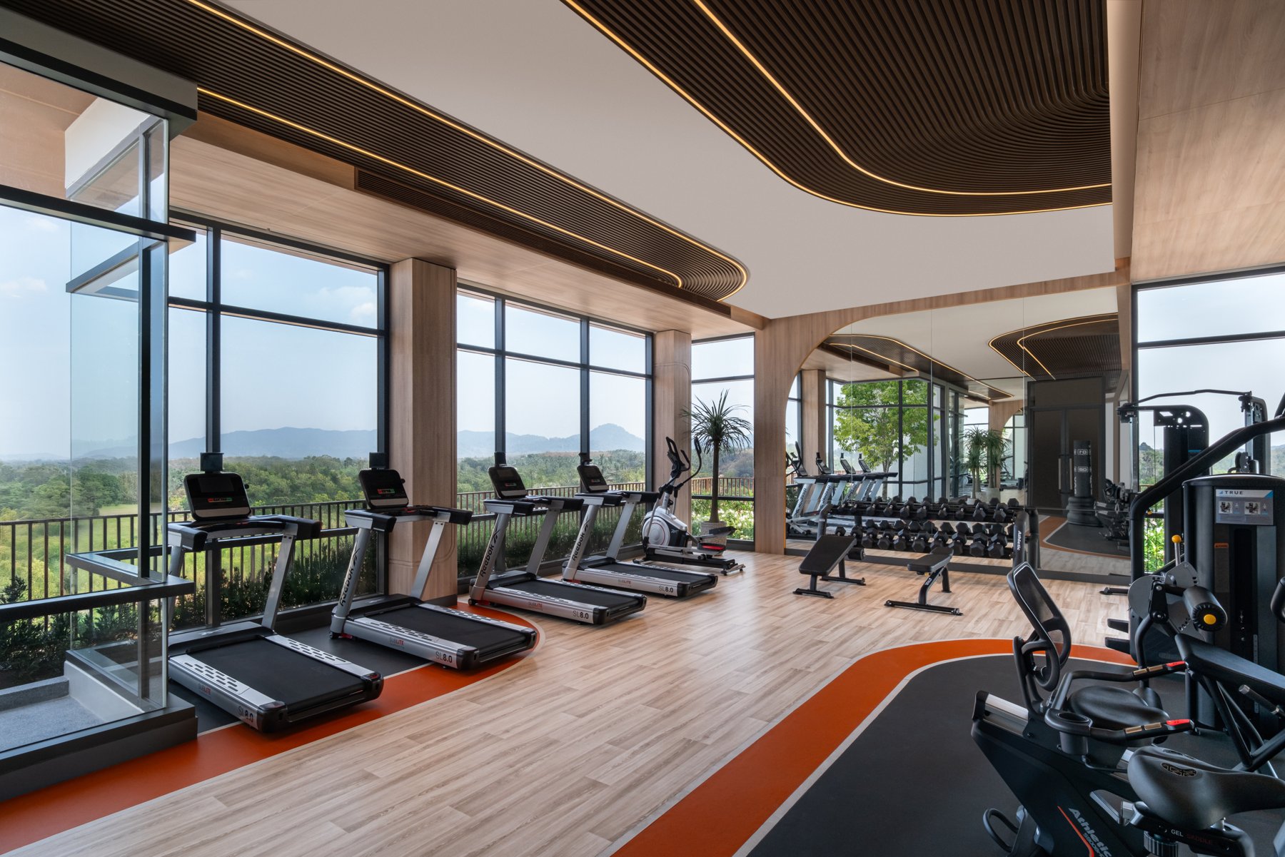 Canvas Cherngtalay: Salle de sport avec des appareils de cardio offrant une vue panoramique sur les montagnes.