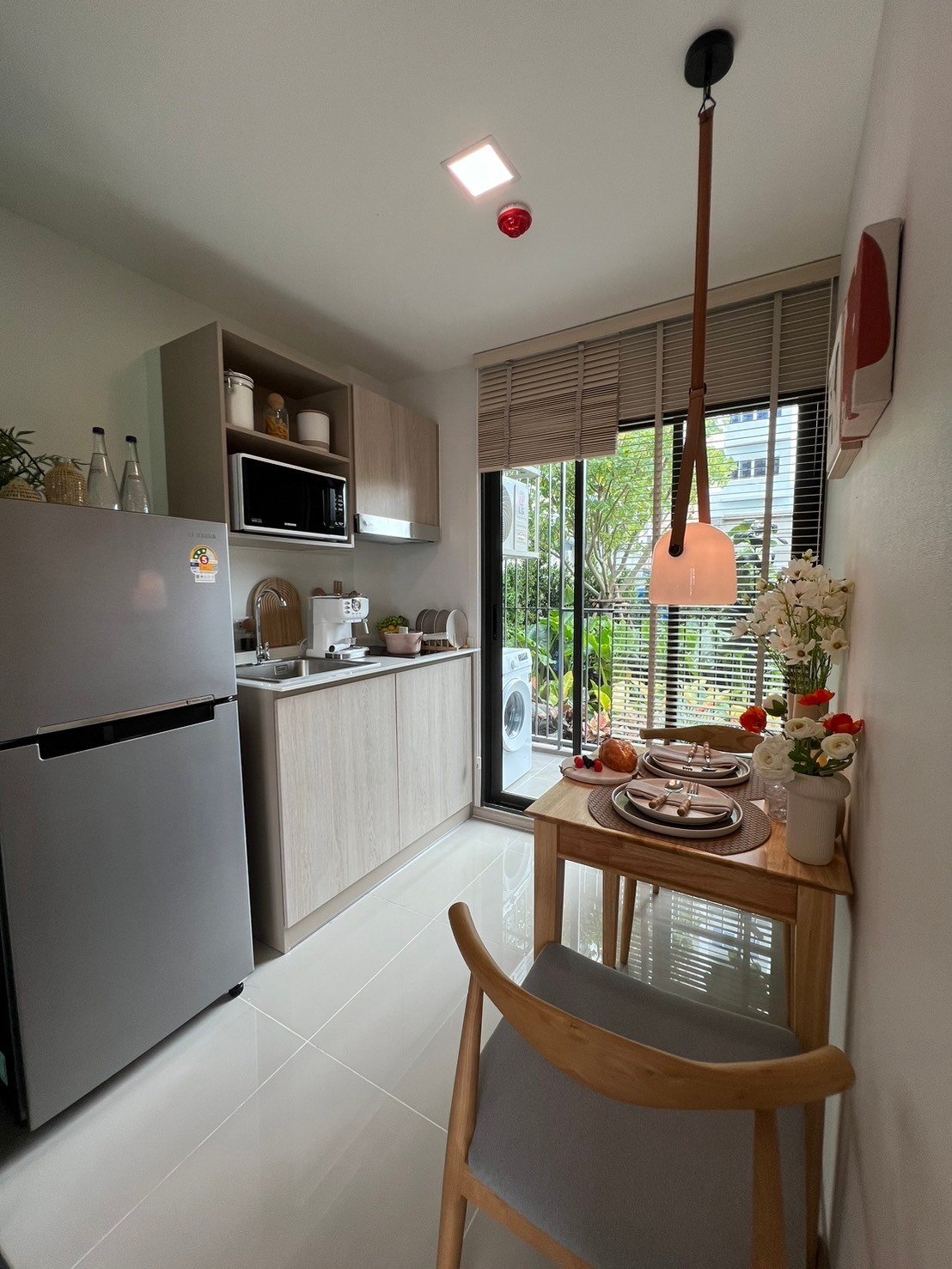 dcondo Calm: Kitchen and dining nook with light wood cabinetry and full-height window.