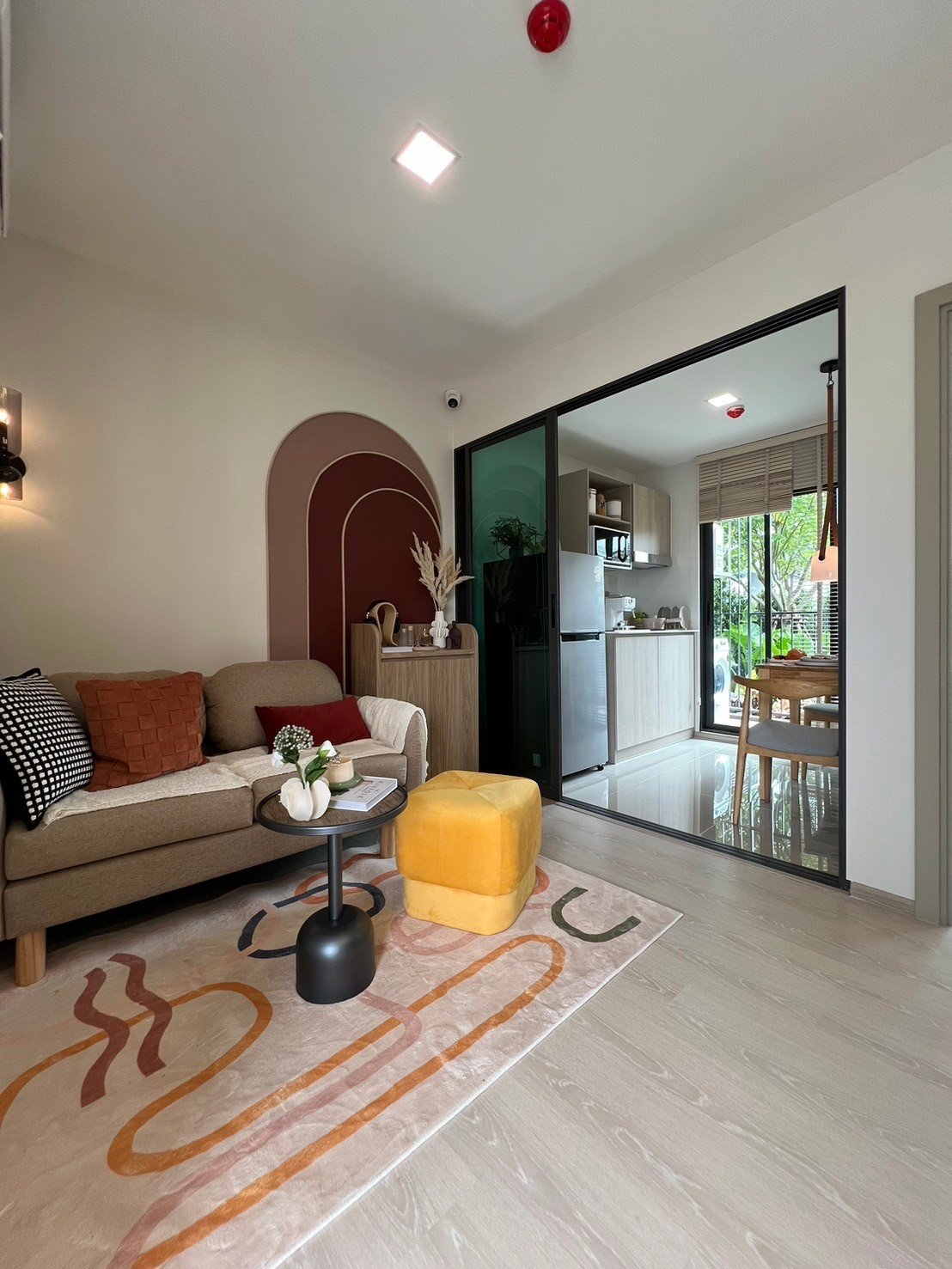 dcondo Calm: Living area with a clear view into the compact kitchen through a partition.