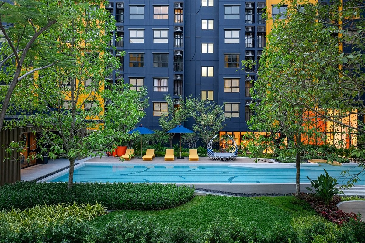 dcondo Shine Rangsit: The main swimming pool surrounded by lush landscaping and residential buildings.
