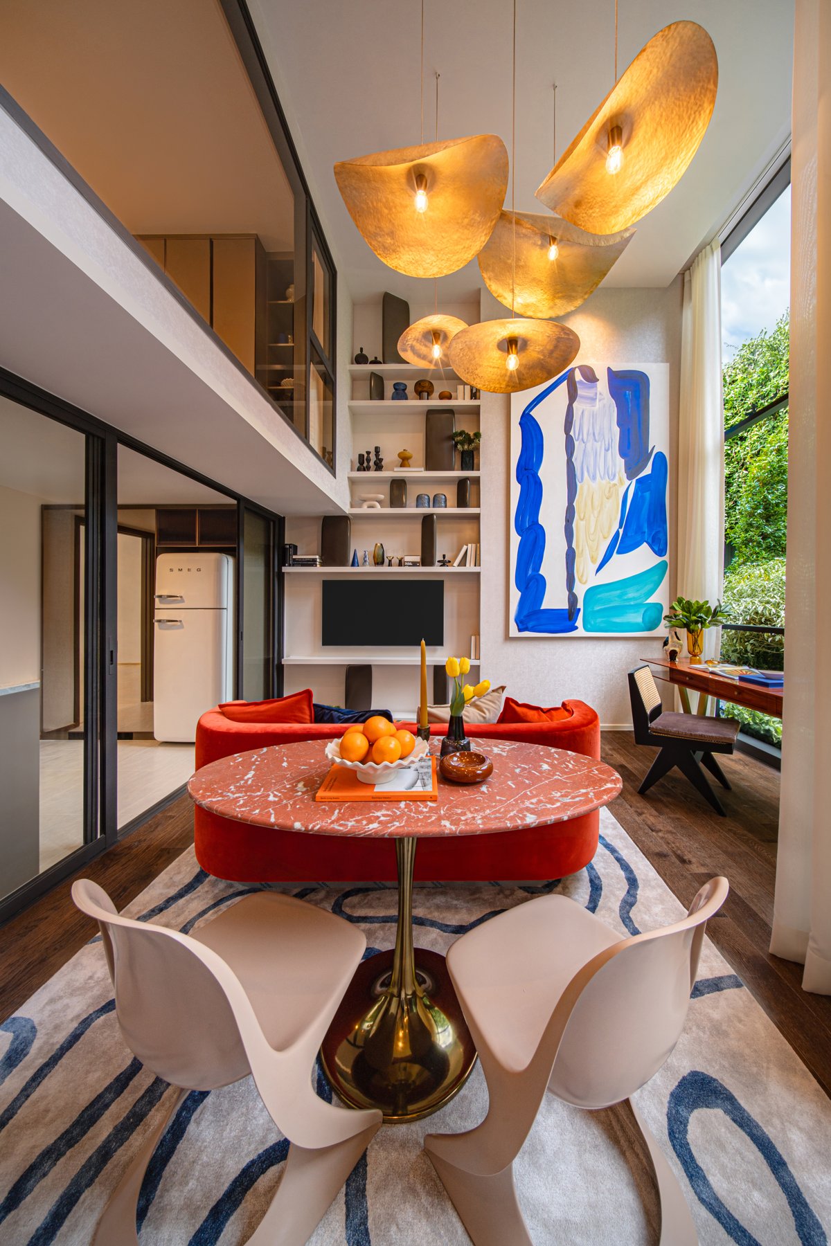 SHUSH Ratchathewi: Salon et salle à manger lumineux dans une unité de type loft avec un éclairage spectaculaire et des baies vitrées.