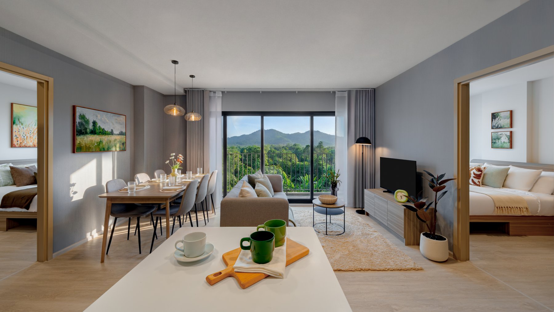 The Base Cherngtalay: Open-plan living and dining area in a two-bedroom unit with mountain views.