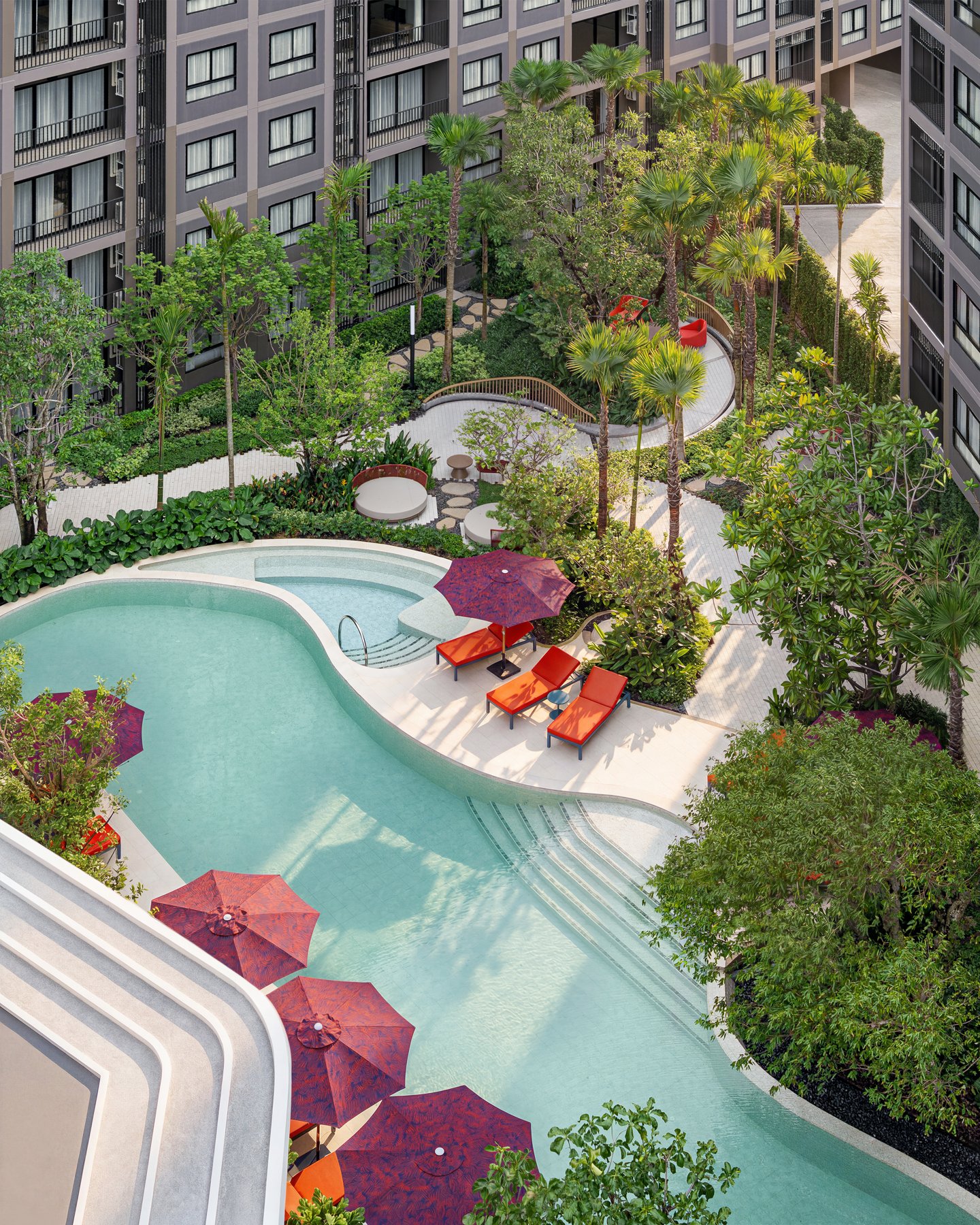 The Base Cherngtalay: View from above of the freeform swimming pool and sunbathing deck.