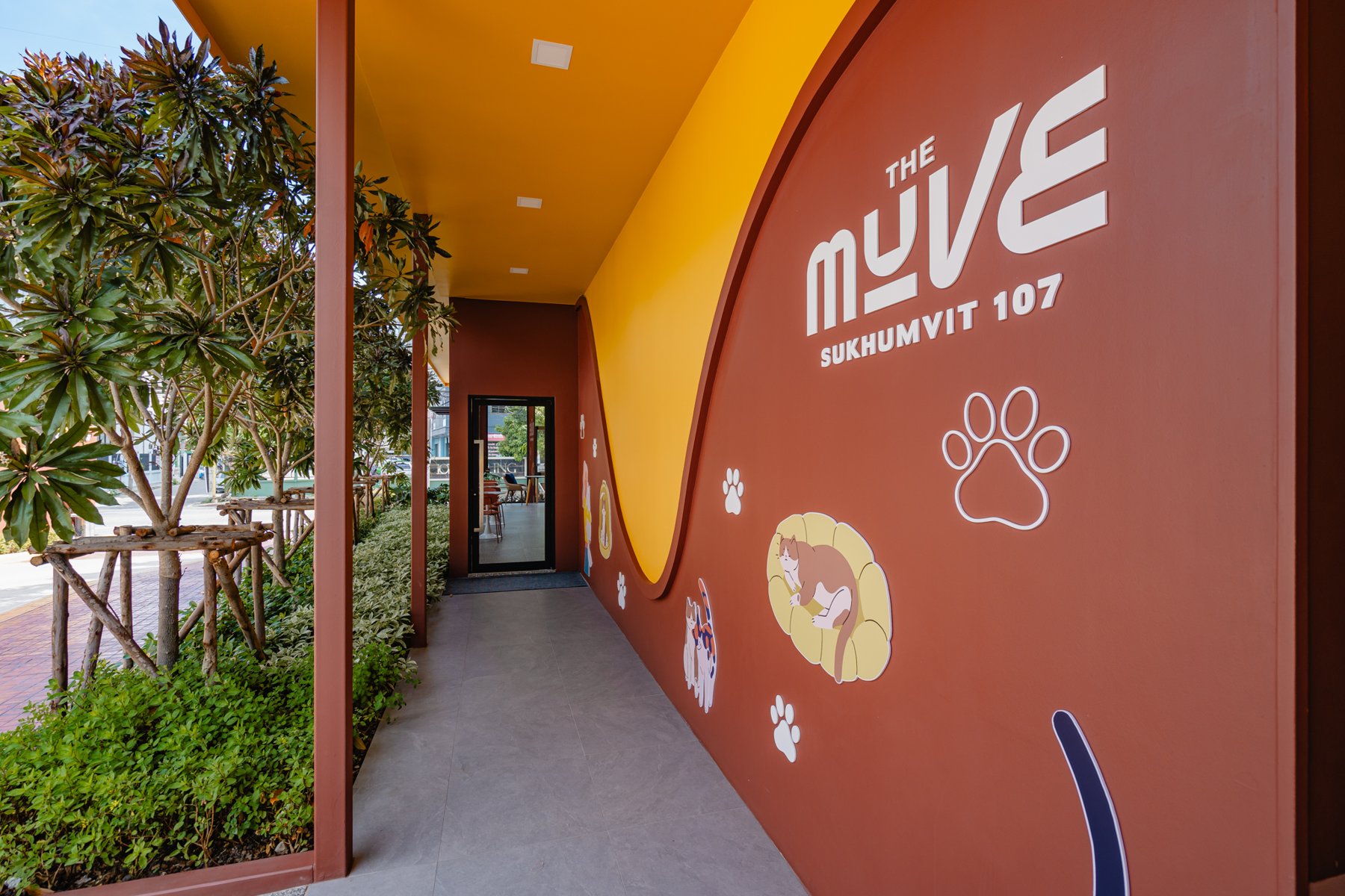The MUVE Sukhumvit 107: Entrance corridor featuring a brightly colored wall with pet illustrations.